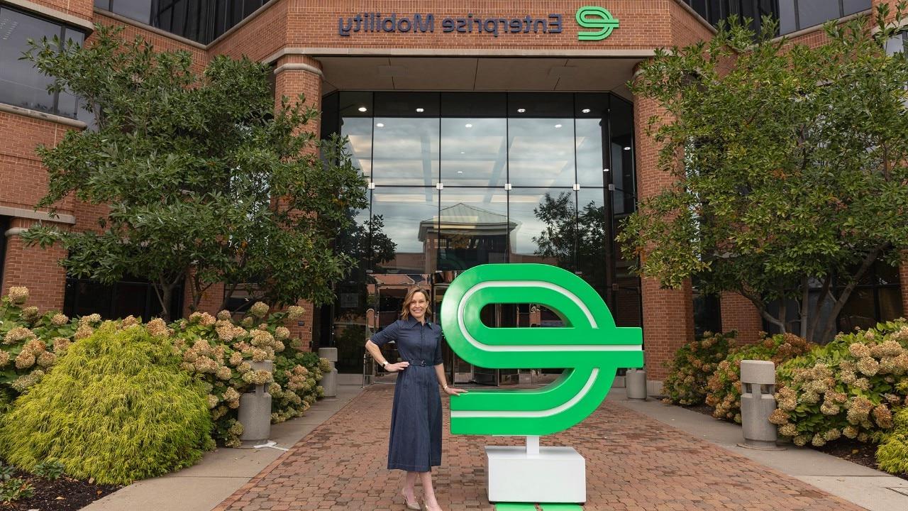 President & CEO Chrissy Taylor, smiling and with her arms folded, in front of a building on the Enterprise Mobility corporate campus in St. Louis.